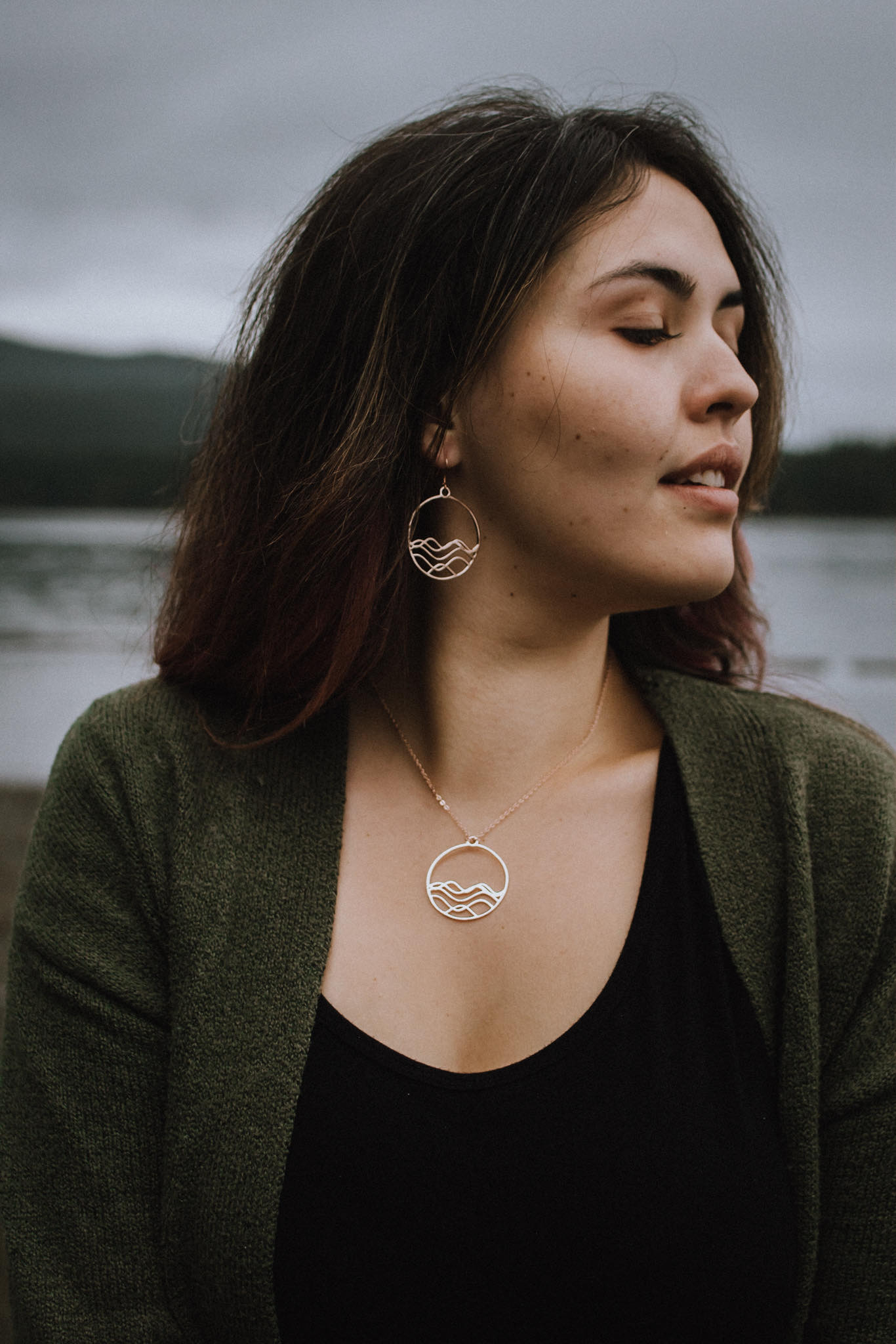 ocean jewelry, Model showing 18k plated rose gold high tide circle earrings and necklace with lake background