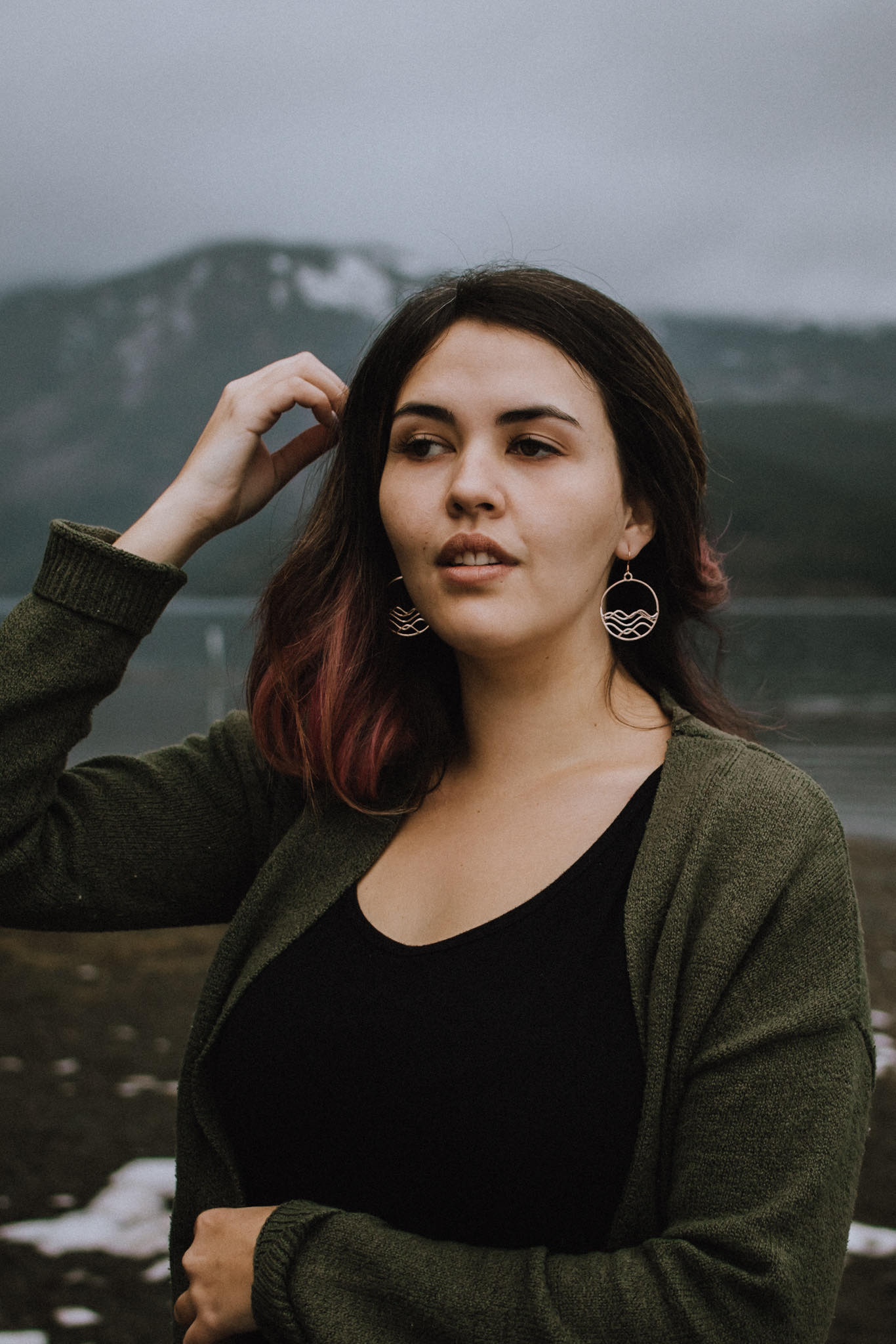 ocean jewelry, Model showing 18k plated rose gold high tide circle earrings and necklace with mountains and water backgound