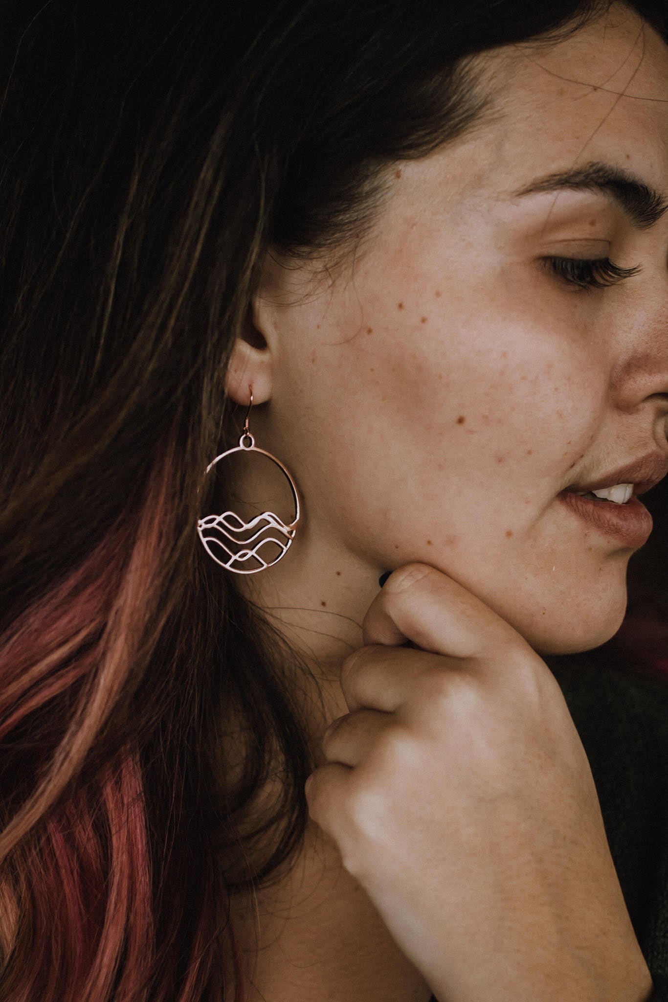 close up of model wearing rose gold plated High Tide circle earrings