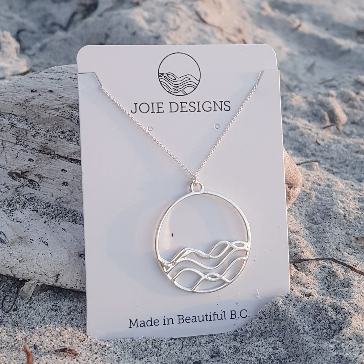 925 sterling silver high tide circle pendant necklace on white jewellery card in the sand
