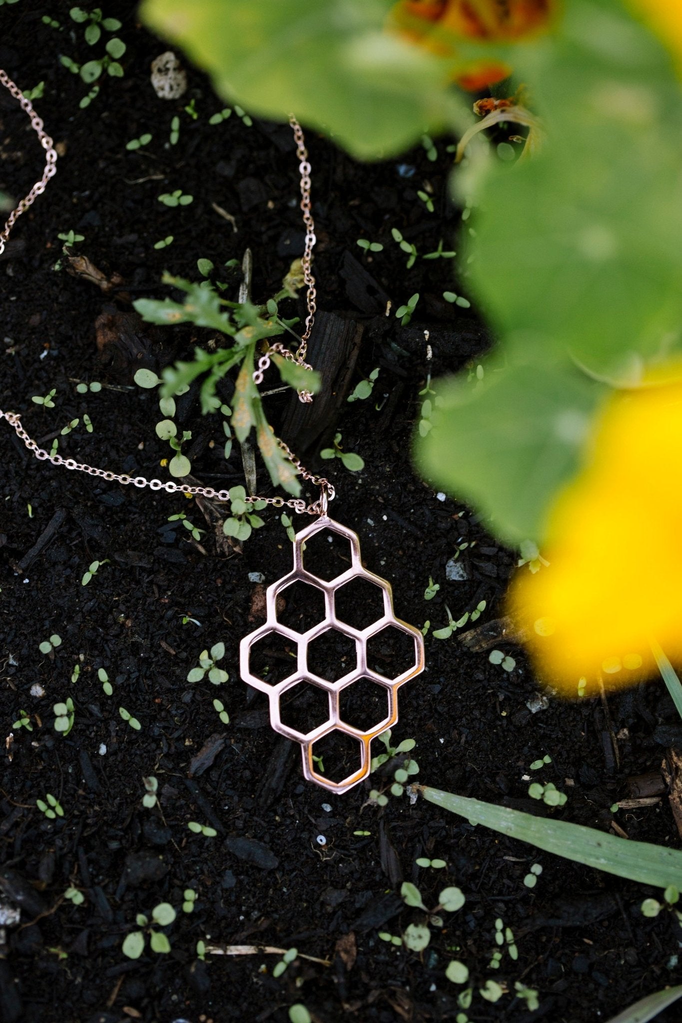 18k rose gold plated honeycomb design pendant necklace with nature background and leaves