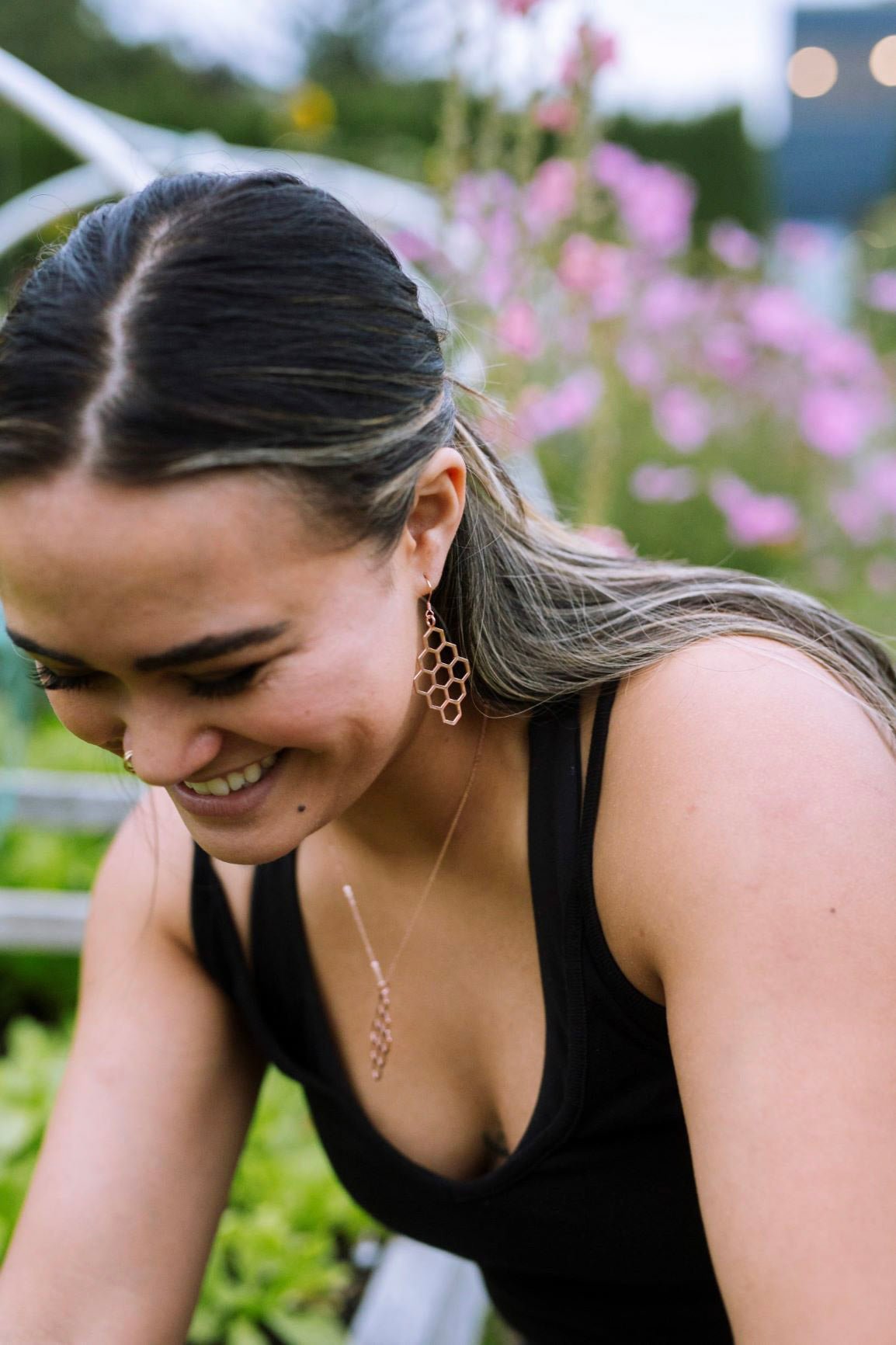 rosie gold honeycomb earrings and necklace on model in the garden with pink flowers