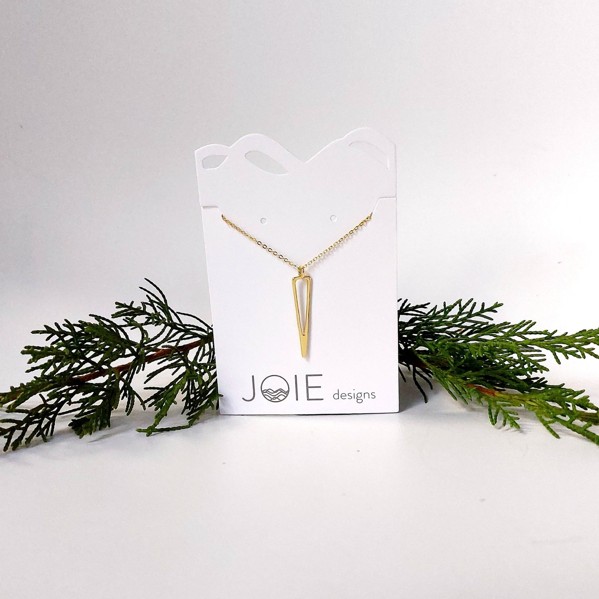 18k yellow gold plated icicle design pendant necklace showcased on a jewellery card with pine and cedar in background