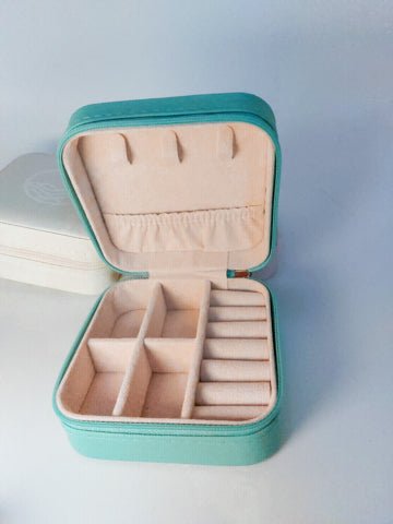 turquoise travel jewelry case with lid open showing the compartments and faux suede inside