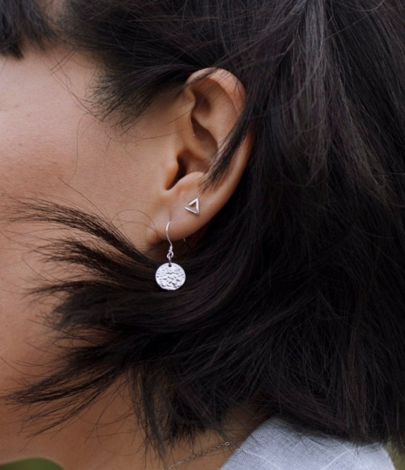 model wearing sterling silver kimberly mountain design stud earrings with nature blur background