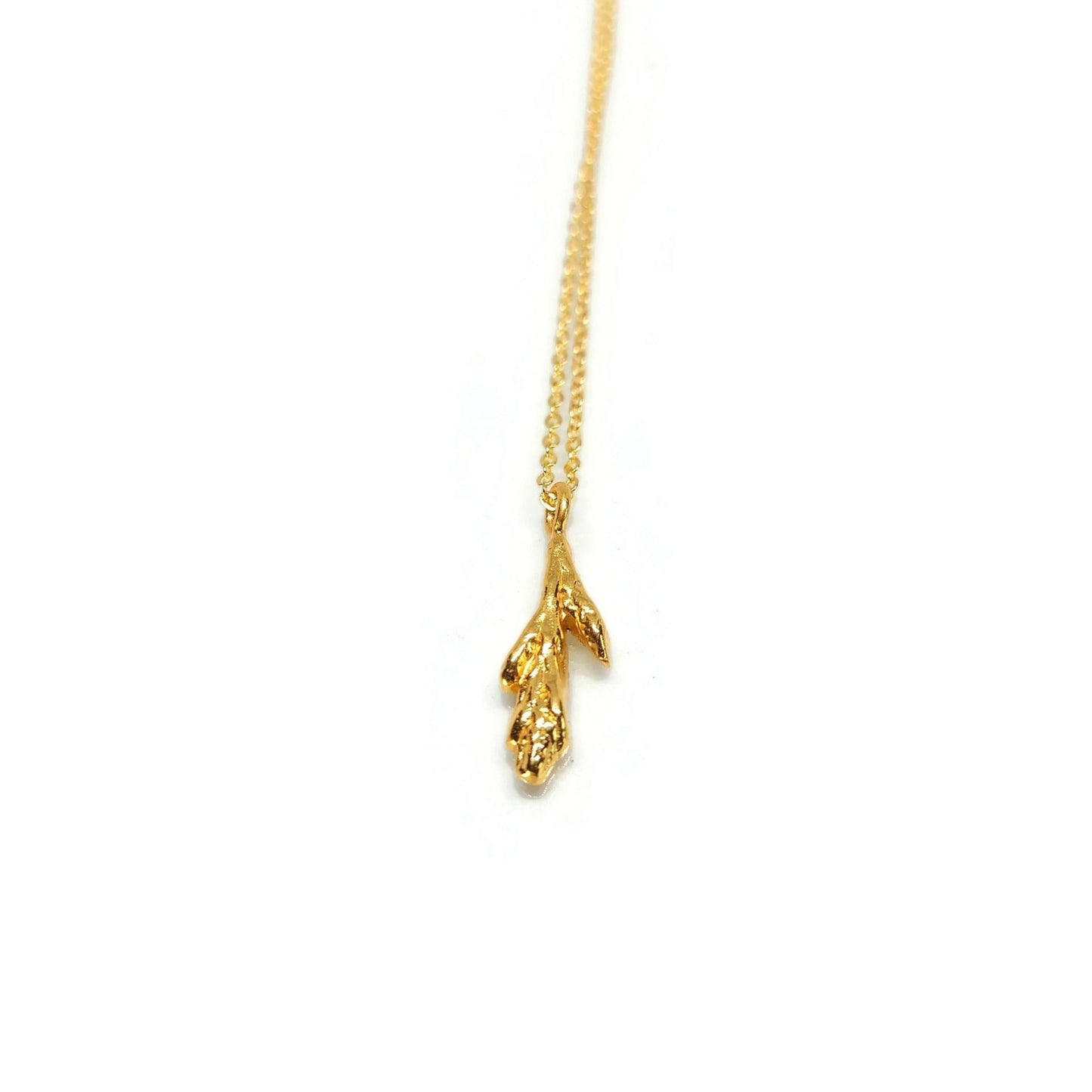gold little cedar leaf pendant on gold chain necklace with white background