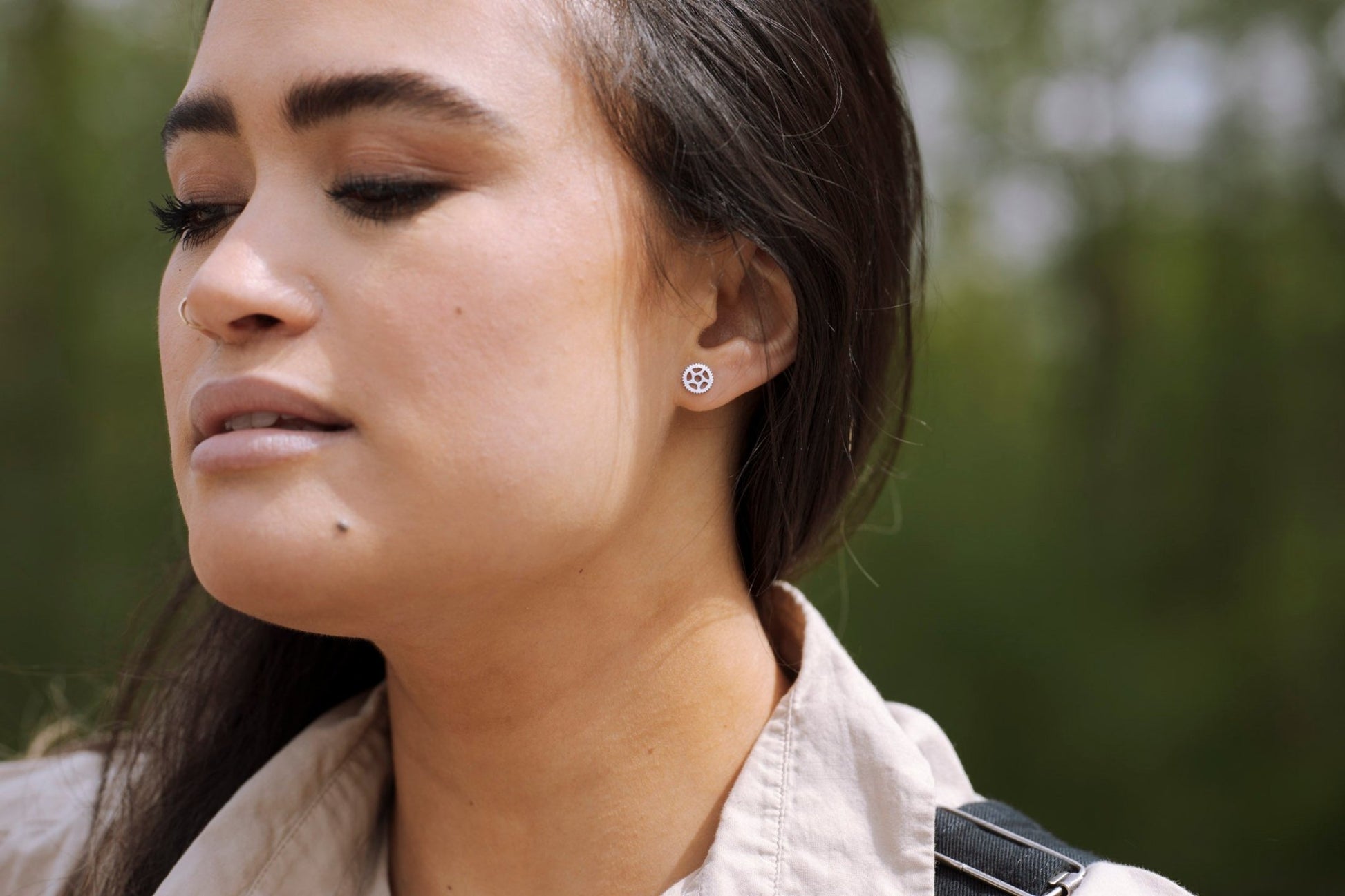 model wearing a 925 sterling silver bike chain ring design stud earring with nature background