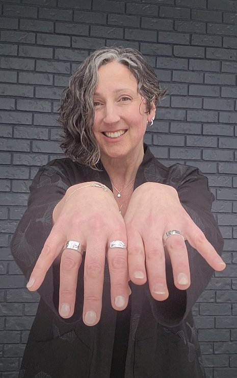 model wearing silver Nerissa and Marley rings with wood natural textures