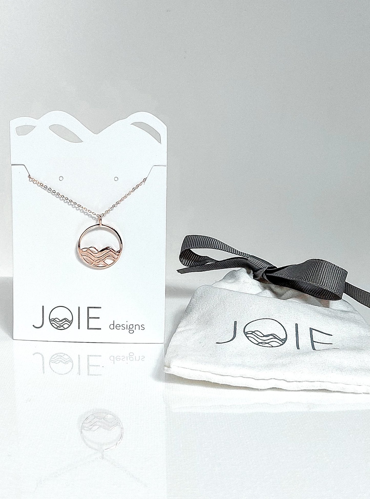 18k rose gold plated petite high tide circle pendant necklace on a white jewelry card, wave necklace, ocean jewelry