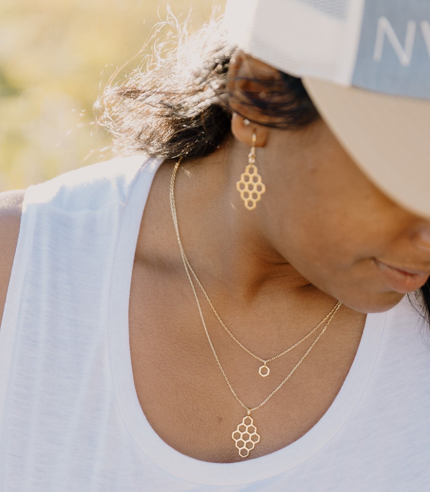 model wearing gold honeycomb necklace layered with mini hexagon gold necklace