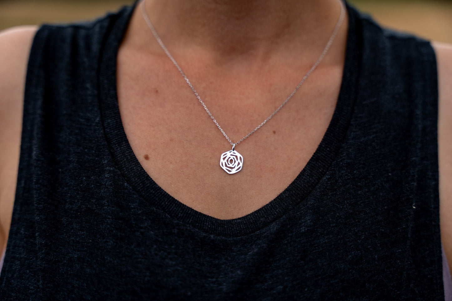 close up of model wearing modern minimalist sterling silver rose flower necklace