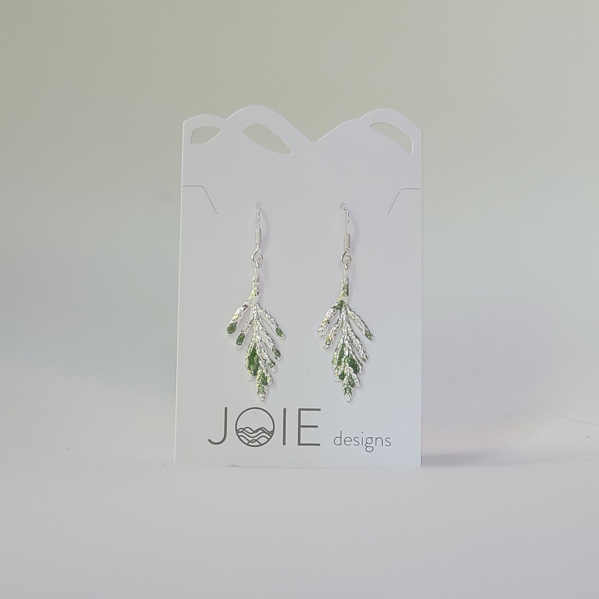 silver cedar leaf dangle earrings embellished with green resin