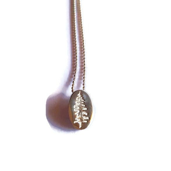18k rose gold plated Sitka Tree embossed into Oval Pendant Necklace hanging on white background