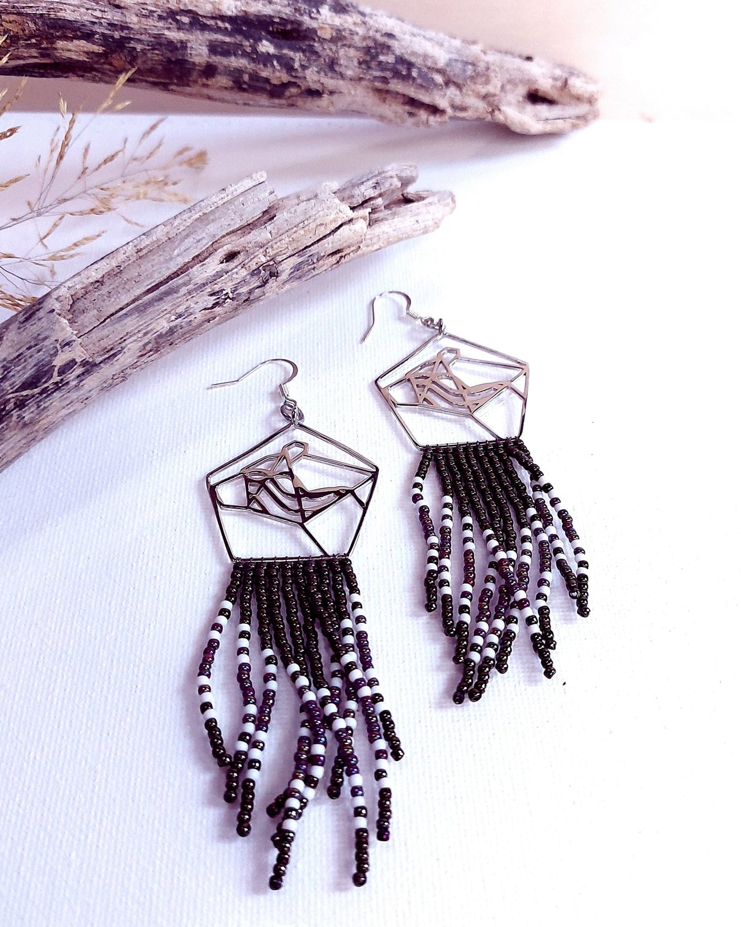 Collaborative art of metal smith and bead artist. Sterling Silver bear head earrings with black and white bead fringes