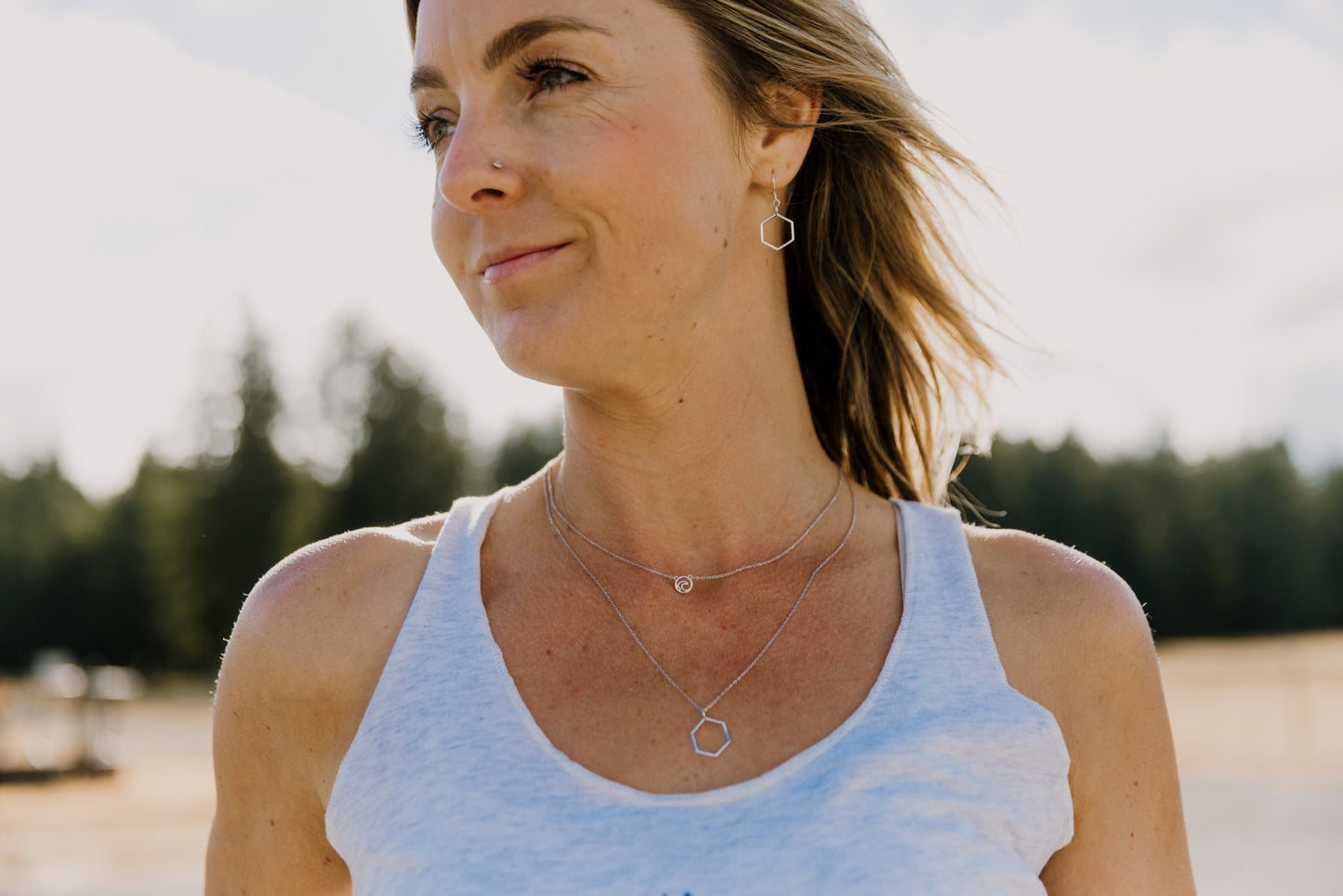 model wearing Tofino wave adjustable necklace layered with honeycomb necklace and wearing honeycomb earrings