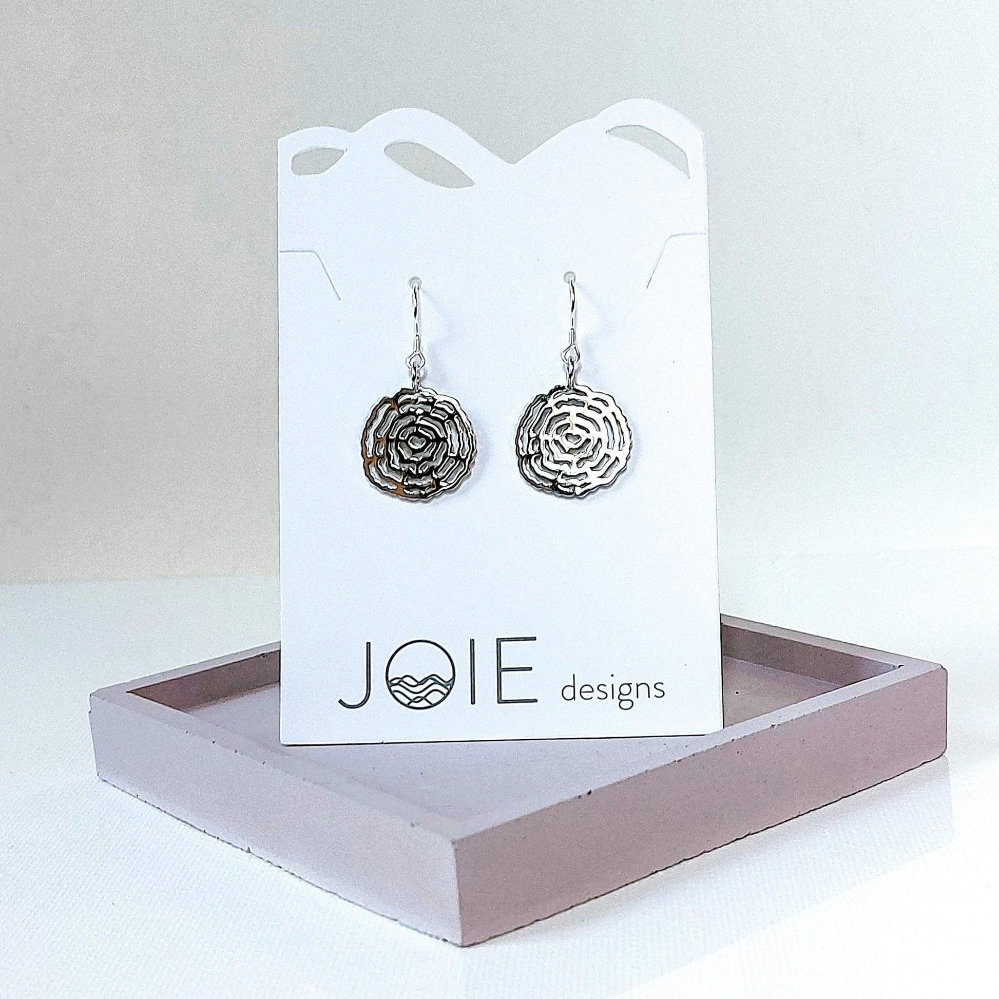 925 sterling silver tree ring inspired dangle earrings shown on a white jewellery card