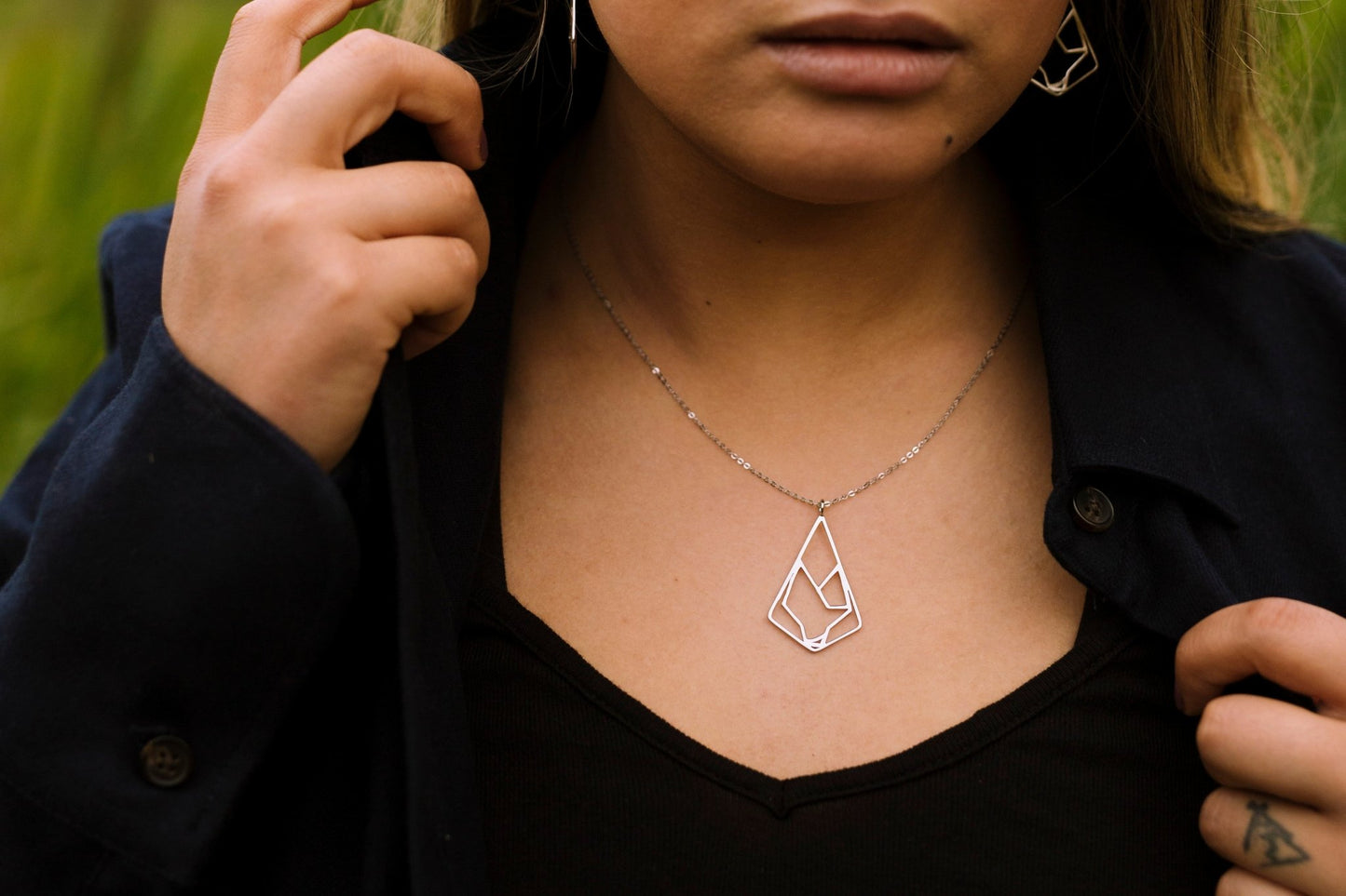 Model wearing 925 sterling silver minimalist diamond shaped wolf pendant necklace
